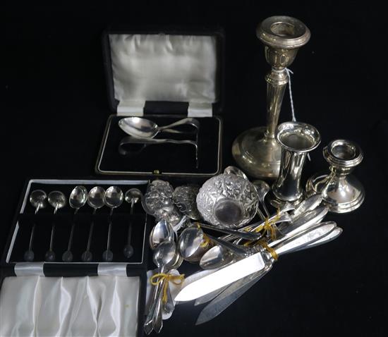 Two silver candlesticks and a small vase (weighted), an Asian embossed white metal small bowl and a similar buckle
